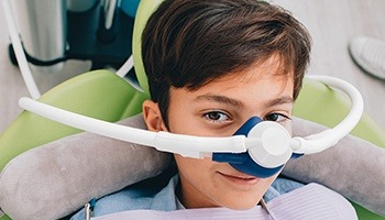 A young boy with a nasal mask preparing to receive nitrous oxide
