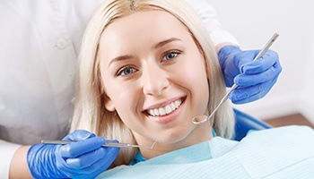 Woman smiling happily during dental examination