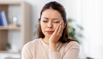 Close-up of woman with toothache sitting on couch