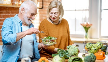 An older couple preparing healthy foods to eat