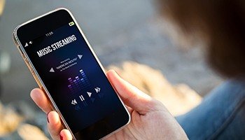 A person listening to streaming music on their iPhone