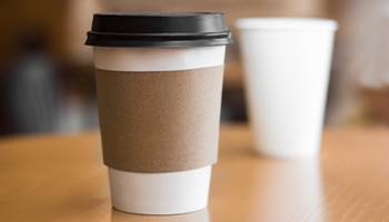 A to-go cup of coffee sitting on a table