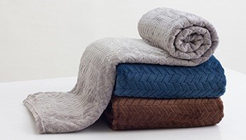 A stack of warm blankets, each in a different color