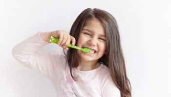 young girl brushing teeth