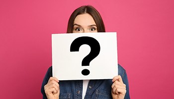 woman holding up sign with question mark 