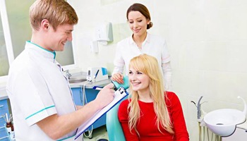 Smiling woman reviewing dental insurance in exam room