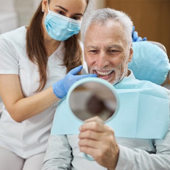 patient smiling and looking in a mirror