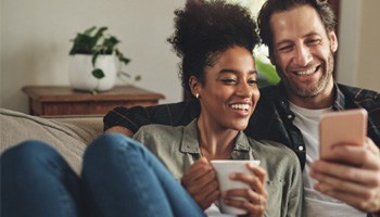 a couple smiling and looking at a phone together