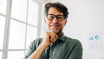a man smiling with his hand resting on his chin
