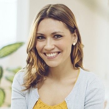 Brunette woman in yellow blouse smiling