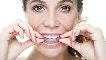 Brunette woman adjusting her invisalign brace