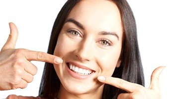 Woman pointing to a healthy, beautiful smile