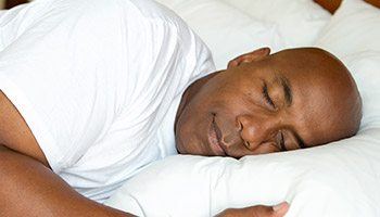 Man resting happily on fluffy bed