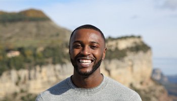 a man smiling and standing outside