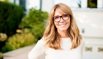 a smiling woman standing outdoors