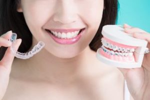 Woman holding a clear tray and braces