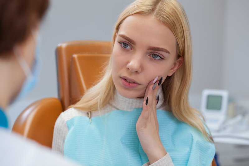 Woman with toothache visiting her dentist in Metarie