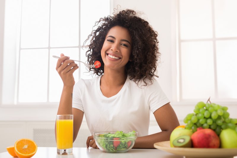 Woman smiling while eating a salad