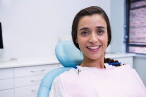 Dental implant candidate smiling while sitting in dental chair
