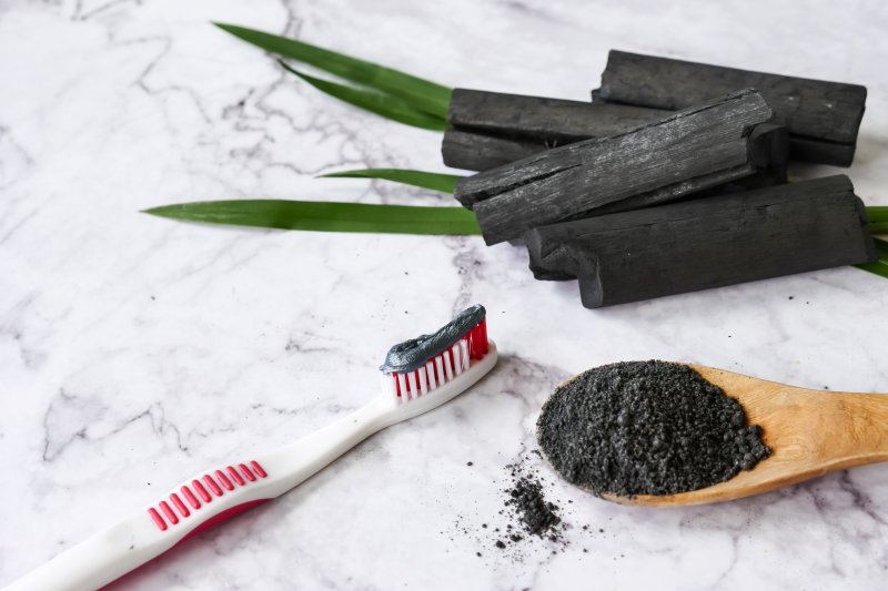 A toothbrush with activated charcoal toothpaste on it