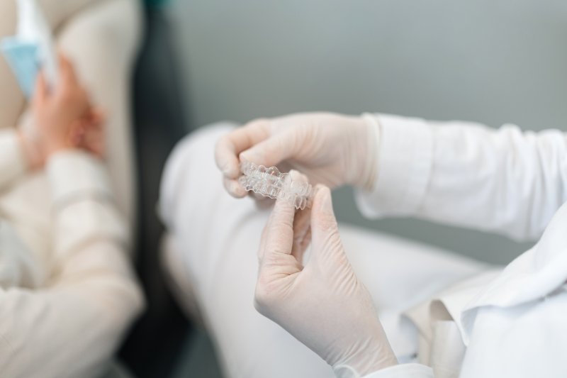 dentist holding Invisalign aligners