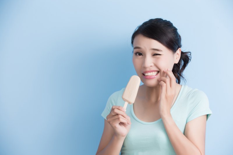 A woman with sensitive teeth eating cold ice cream